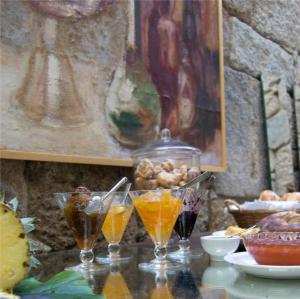 einen Tisch mit drei Gläsern Orangensaft darauf in der Unterkunft Casa Museu in Vouzela