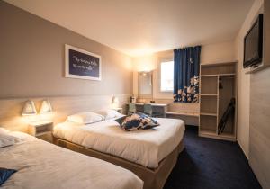 サロン・ド・プロヴァンスにあるAce Hôtel Salon de Provenceのベッド2台とテレビが備わるホテルルームです。