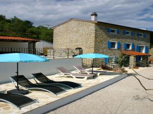 a group of chairs and umbrellas in front of a building at Villa Kentic in Buzet