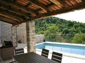 a patio with a table and a swimming pool at Villa Kentic in Buzet