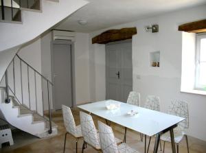 a white dining room with a table and chairs at Villa Kentic in Buzet