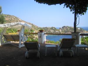 twee stoelen en een schommel en uitzicht op de oceaan bij La Bouganville in Giglio Porto