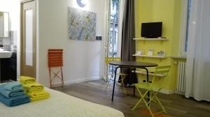 トリノにあるCa'cita Guest House Torinoのベッド、テーブル、テレビが備わる客室です。