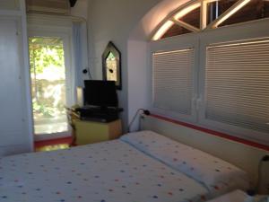 a bedroom with a bed and a window at La Bouganville in Giglio Porto