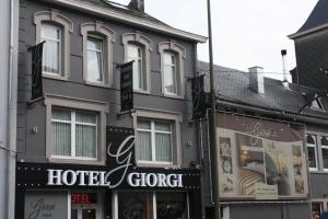 a building with a hotel and a group of stores at Hotel Giorgi in Bastogne