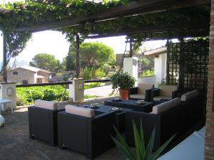 een pergola met tafels en stoelen op een patio bij La Bouganville in Giglio Porto