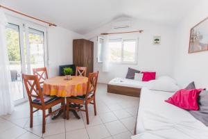 a room with a table and chairs and a bed at Apartmani Maleš in Rogoznica +31 photos