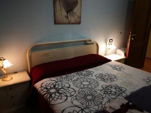 a bedroom with a bed with a flowered blanket at Casa Bruno B&B in Mondovì