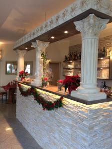 a bar with a pillar in the middle of a building at Hotel Restaurant Artemis in Weisenheim am Berg