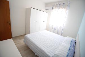 
a bed room with a white bedspread and a blue wall at Vista Mare Rivabella in Gallipoli
