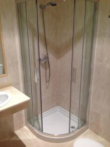 una ducha con puerta de cristal en un baño en H&V Codesal, en Sanxenxo