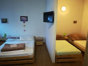 a room with two beds and a tv on the wall at Pokoje U Anny i Łukasza in Swornegacie 