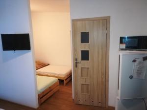 a small room with a door and a refrigerator at Pokoje U Anny i Łukasza in Swornegacie 