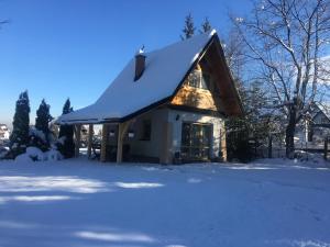 a house with a snow covered roof in the snow at Domek u Mikołaja in Zakopane