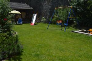 um quintal com um parque infantil com um baloiço em Haus Hofer em Barbiano