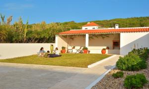 un groupe de personnes assises dans la cour d'une maison dans l'établissement Villa over the Ocean in Magoito-Sintra, à Sintra