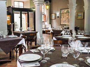een eetkamer met tafels en stoelen met wijnglazen bij S´Hostal d´Esporles in Esporles