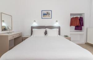 a bedroom with a large bed with white sheets at Milos Apartments in Adamantas
