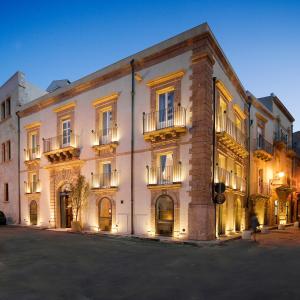 a large building with a clock on the front of it at Algilà Ortigia Charme Hotel in Syracuse
