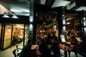 a group of people sitting at tables in a restaurant at Caramel Boutique Hotel in Beirut