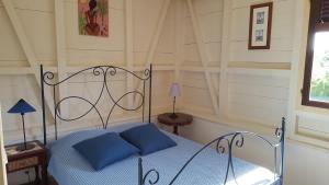 1 dormitorio con 1 cama con almohadas azules en Villa Alizia, en Saint-François