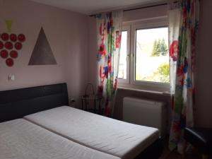 - une chambre avec un lit et une fenêtre avec des rideaux dans l'établissement FeWo und Zimmer Egert, à Hattenheim