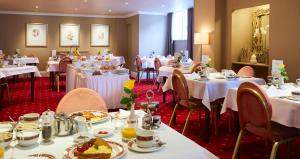 een eetkamer met witte tafels en stoelen bij Riviera Town House in Scarborough