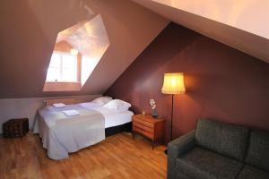 Cette chambre mansardée comprend un lit et une chaise. dans l'établissement Grettir Guesthouse, à Reykjavik