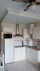 a kitchen with white cabinets and a ceiling at Daria in La Mata +10 photos