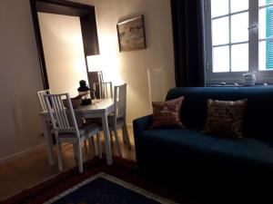 un soggiorno con un divano blu e un tavolo di Cosy Little House a Genova
