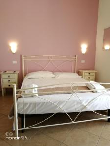 a bedroom with a white bed with two night stands at Zahir da Cleo in Castro di Lecce