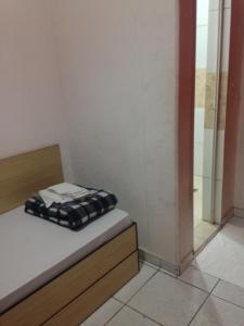 a small room with a bed and a shower at Hotel Florêncio in Sao Paulo