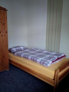 uma pequena cama num quarto com uma estrutura de cama em Monteur - Ferienwohnung Marburg - Biedenkopf - Steffenberg - mit 4 Zimmer und Balkon em Obereisenhausen