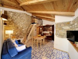 sala de estar con sofá azul y mesa en Residenza Matarazzo e Le Sue Soffitte, en Castellabate