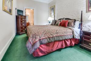 - une chambre avec un grand lit et un tapis vert dans l'établissement Plaza Suites Downtown New Orleans, à La Nouvelle-Orléans