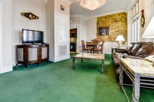 a living room with a couch and a tv at Plaza Suites Downtown New Orleans in New Orleans