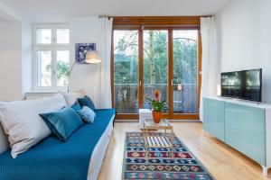 ein Wohnzimmer mit einem blauen Sofa und einem TV in der Unterkunft GreatStay - Zionskirchstr. 5 in Berlin
