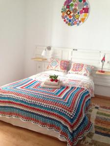1 dormitorio con 1 cama con colcha colorida en El Taller del Abuelo, en Córdoba