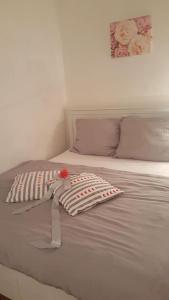 a white bed with a pillow with a rose on it at Penzion-apartmán U Johana in Moravská Třebová