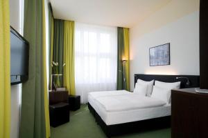 um quarto de hotel com uma cama e uma televisão em Rainers Hotel Vienna em Viena