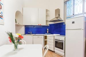 a kitchen with white appliances and a table with a vase of flowers at Magenta 55 in Turin