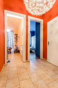 a hallway with orange walls and a chandelier at Magenta 55 in Turin