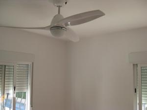 Habitación blanca con ventilador de techo y ventana en Hello Oliva Beach Alter, en Oliva