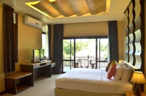 a bedroom with a large bed and a balcony at Palm Leaf Resort Koh Tao in Ko Tao