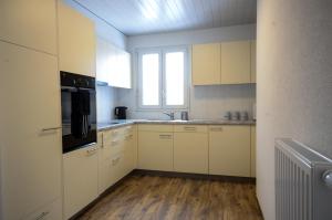 cocina grande con armarios blancos y ventana en Interlaken Central 2, en Interlaken
