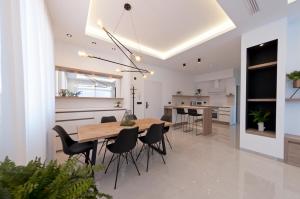 cocina y comedor con mesa de madera y sillas en Apartamentos La Laguna I Luxury Apartments, en Guardamar del Segura