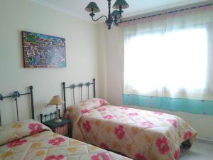 a bedroom with two twin beds and a window at L&C Codesal in Sanxenxo +3 photos