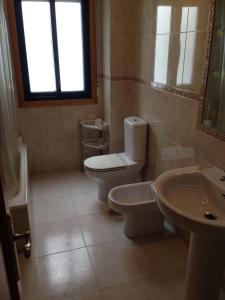 a bathroom with a toilet and a sink at L&C Codesal in Sanxenxo