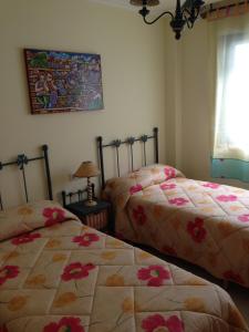 a bedroom with two beds and a picture on the wall at L&C Codesal in Sanxenxo