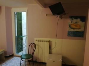 a room with a chair and a television on the wall at Hotel La Zorza in Riomaggiore